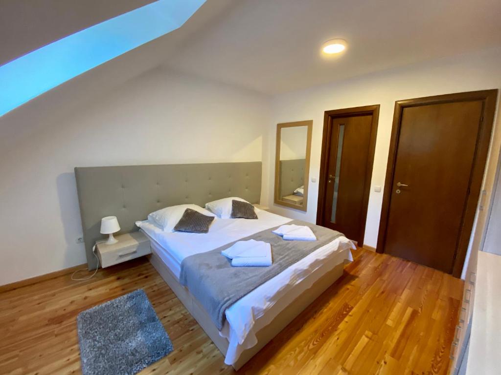 a bedroom with a large white bed and wooden floors at Casa Edelweiss in Sinaia