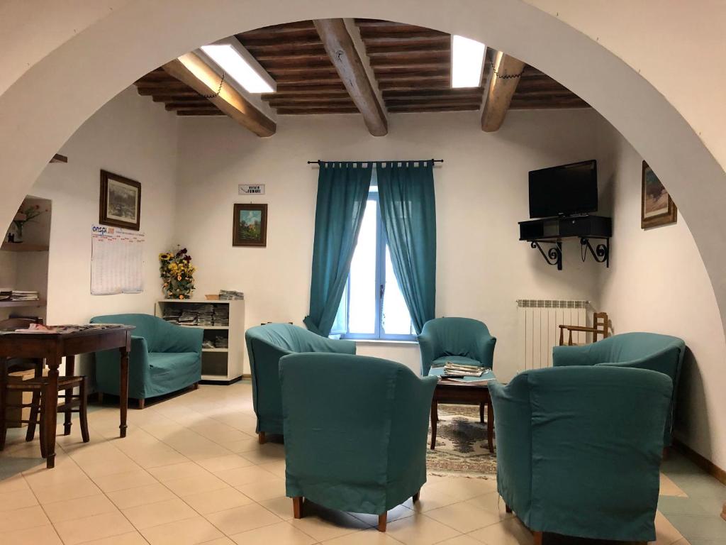 un soggiorno con sedie, tavolo e finestra di Residenza Pitigliano a Pitigliano