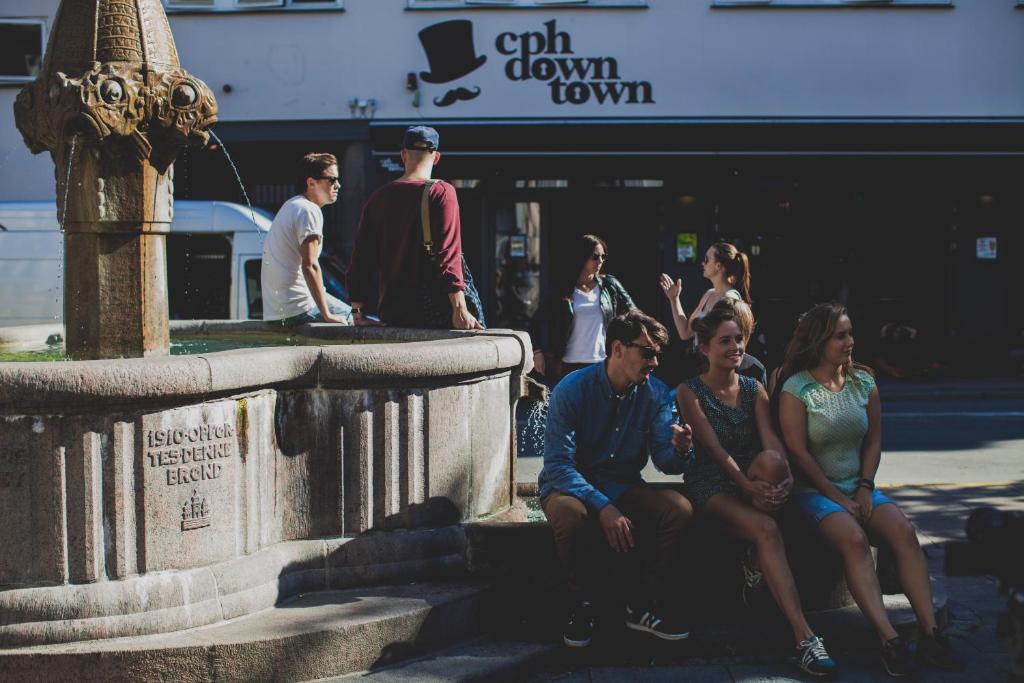 grupa ludzi siedzących obok fontanny w obiekcie Copenhagen Downtown Hostel w Kopenhadze