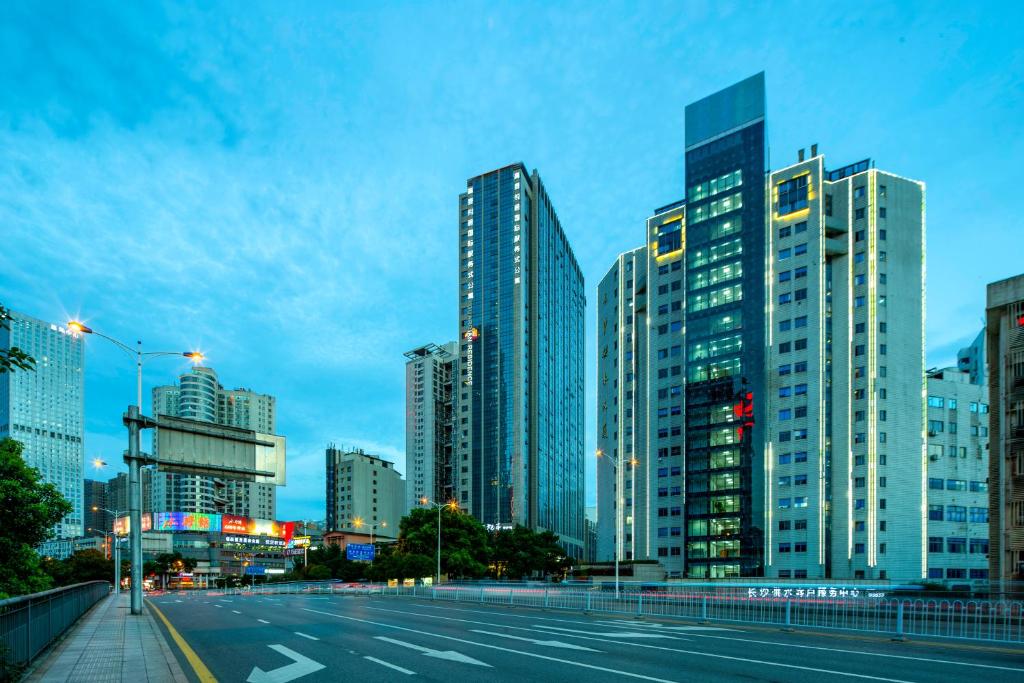 una ciudad con edificios altos y una calle al atardecer en Guardian Residence, en Changsha