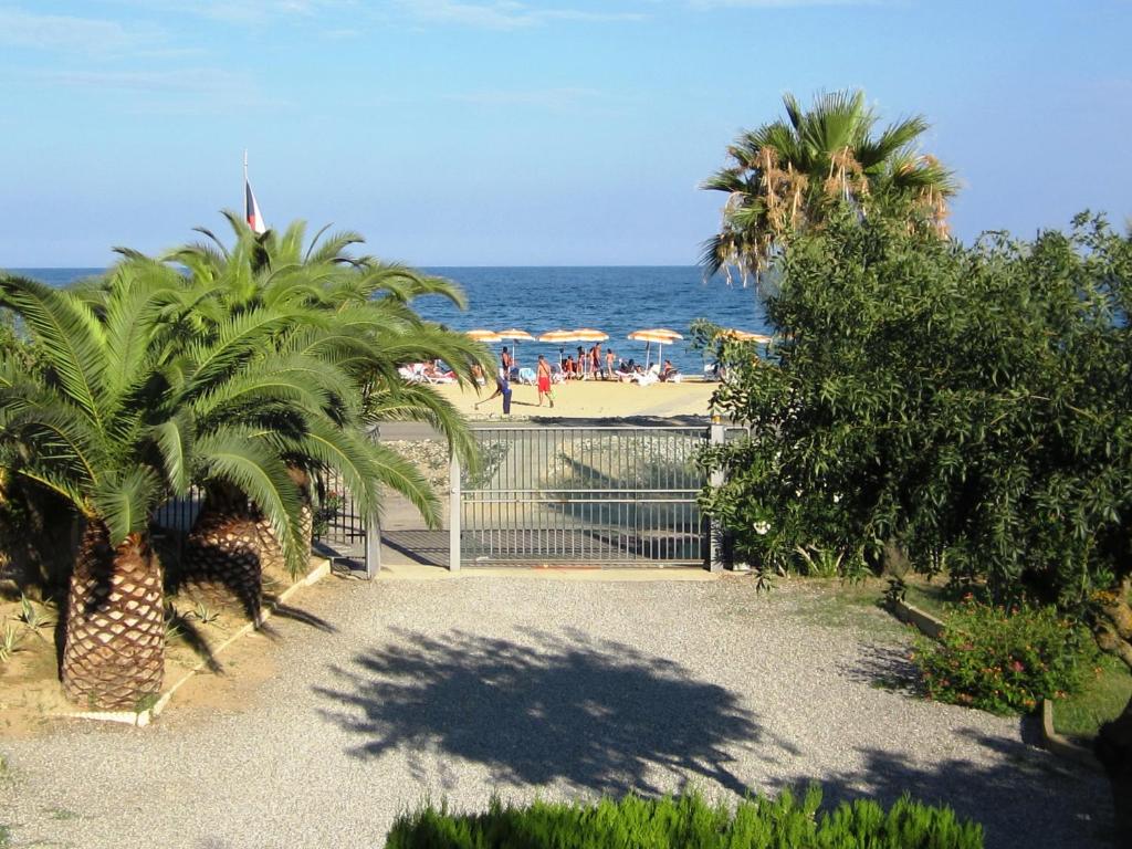 a gate leading to a beach with palm trees at Residence Torre Saracena in Villapiana