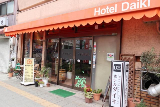 a hotel building with a sign in front of it at Hotel Daiki in Osaka
