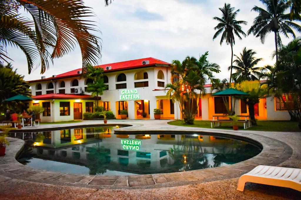 ein Hotel mit einem Pool vor einem Gebäude in der Unterkunft Grand Eastern Hotel in Labasa