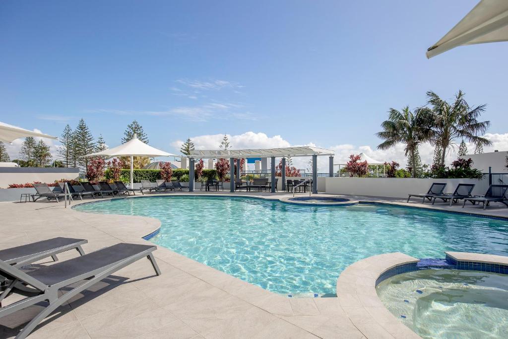una grande piscina con sedie e tavoli di Mantra Mooloolaba Beach a Mooloolaba