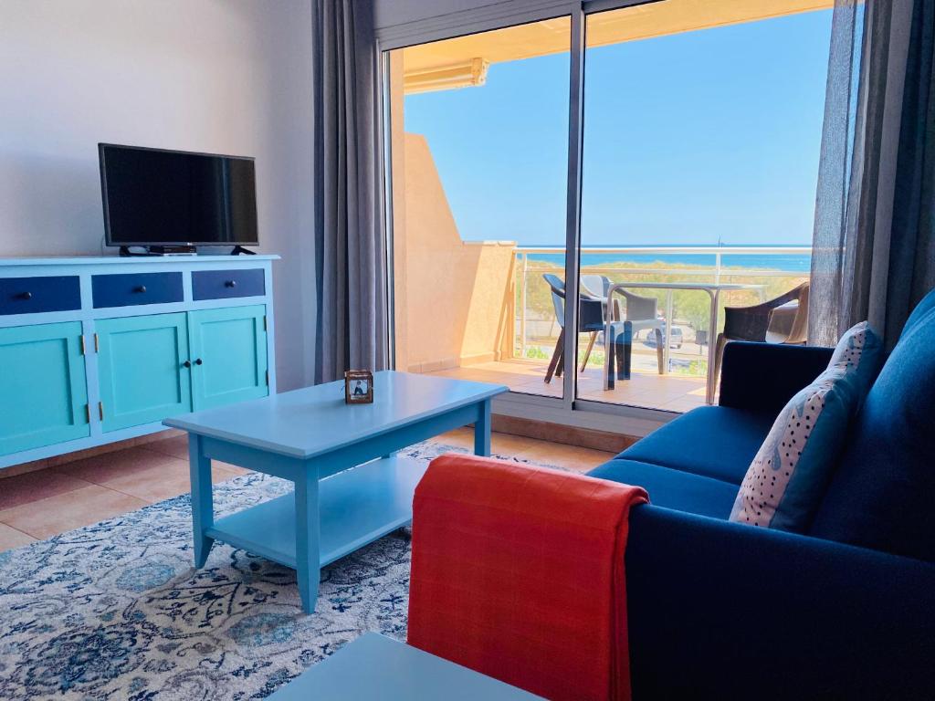 sala de estar con sofá, mesa y ventana en Playa Pals Sea View - Plus Costa Brava, en Pals