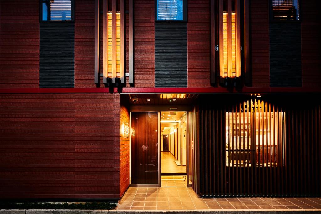 un pasillo que conduce a un edificio con puerta en Guest House Wagokoro, en Tokio