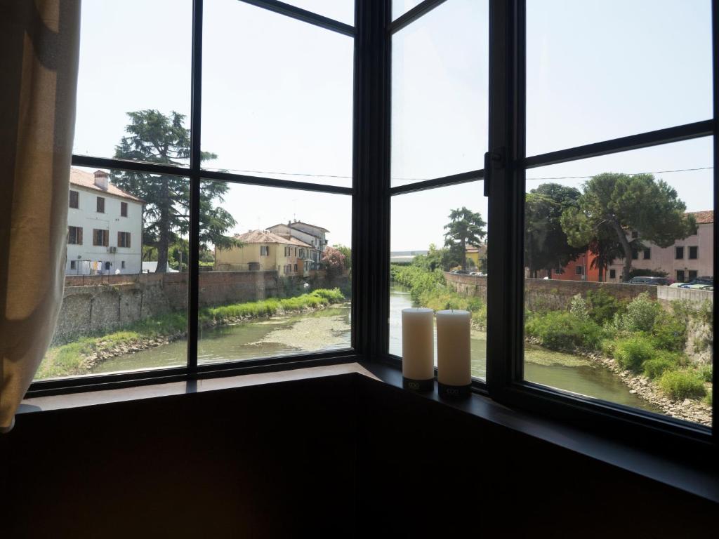 una ventana con tres velas sentadas en un alféizar de la ventana en Dimora Arco di Mezzo en Battaglia Terme