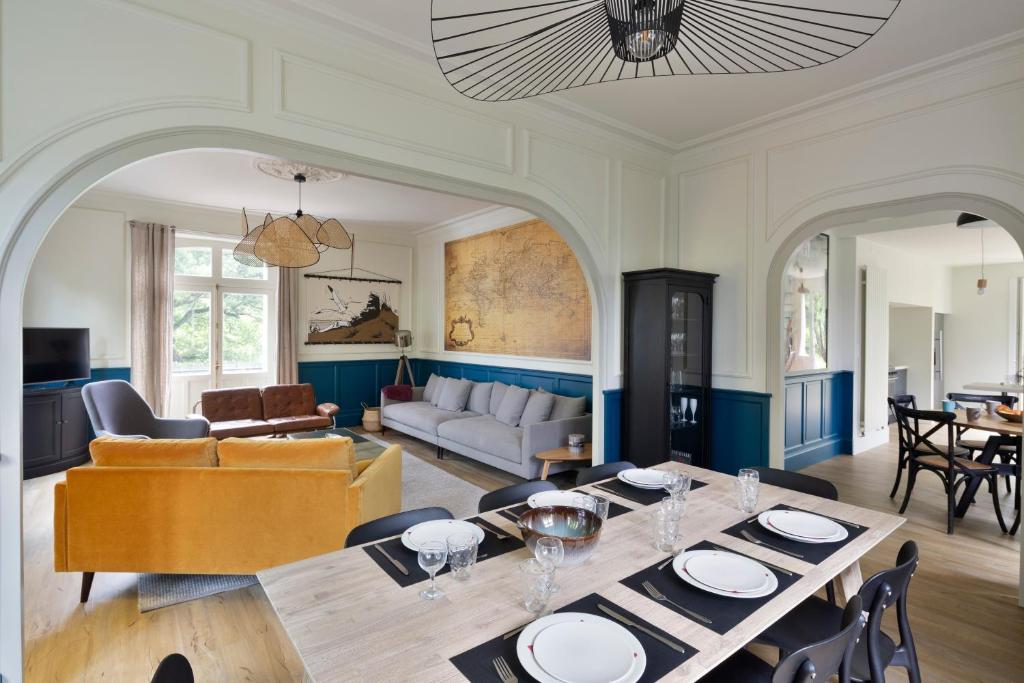 una sala da pranzo e un soggiorno con tavolo e sedie. di Villa Marlotte by Cocoonr - La Belle de Dinard a Dinard