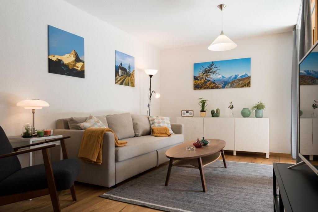 uma sala de estar com um sofá e uma mesa em Montela Hotel & Resort - Apartments em Saas-Grund