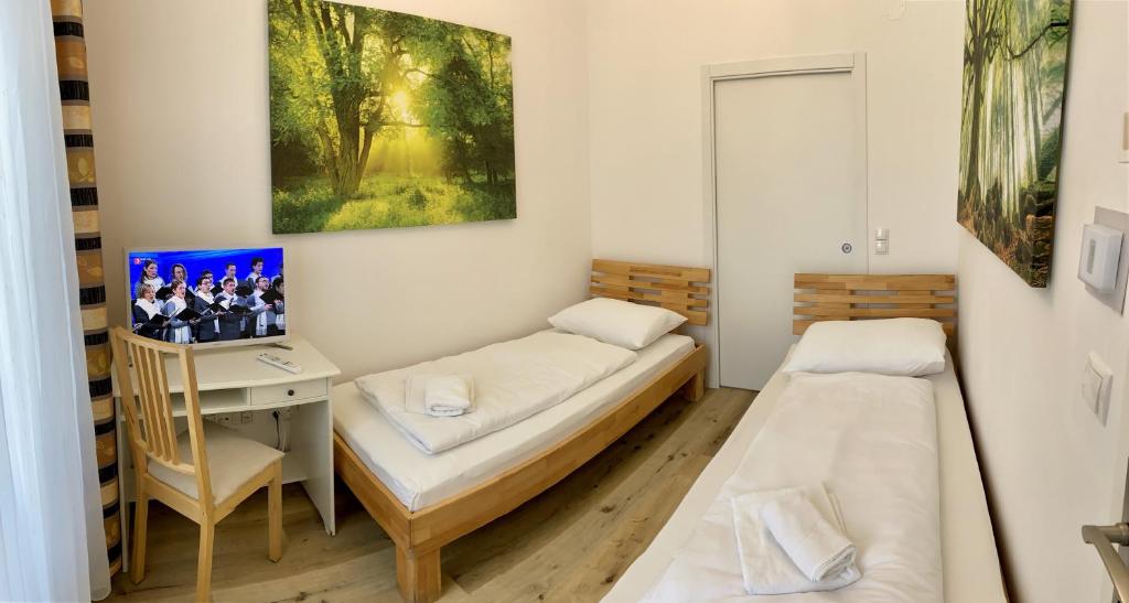 a room with two beds and a desk and a tv at AJO Vienna Central Room - Contactless Check-in in Vienna