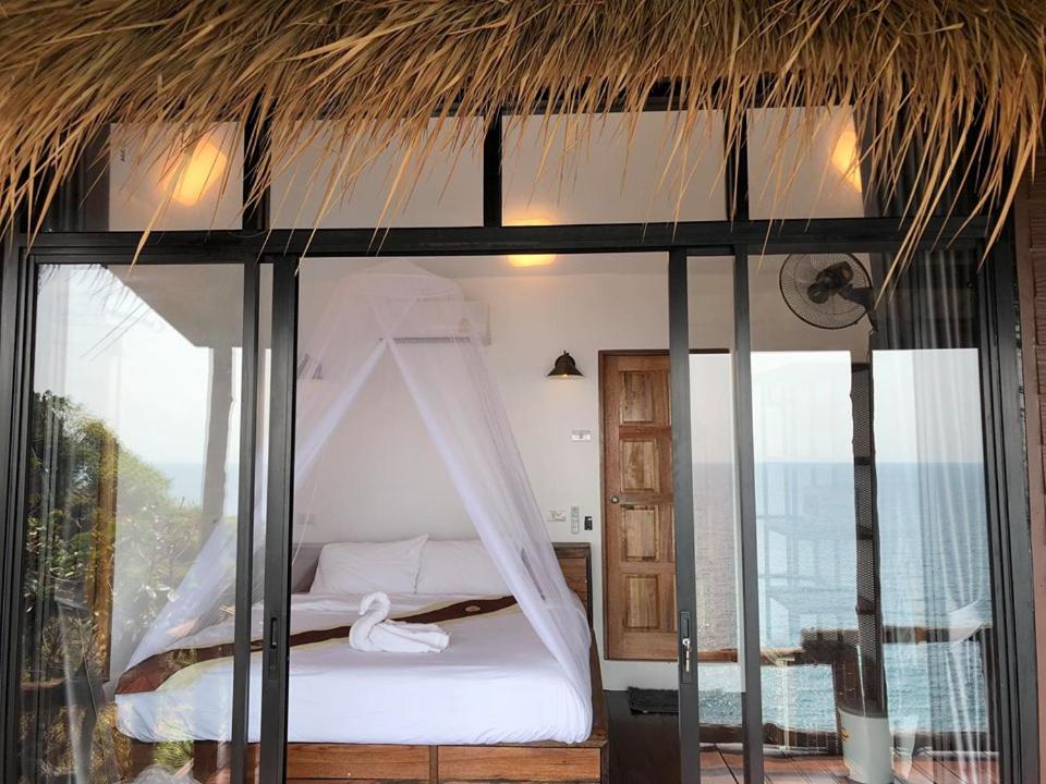 龜島的住宿－月光之舞美景別墅酒店，一间卧室配有一张带蚊帐的床
