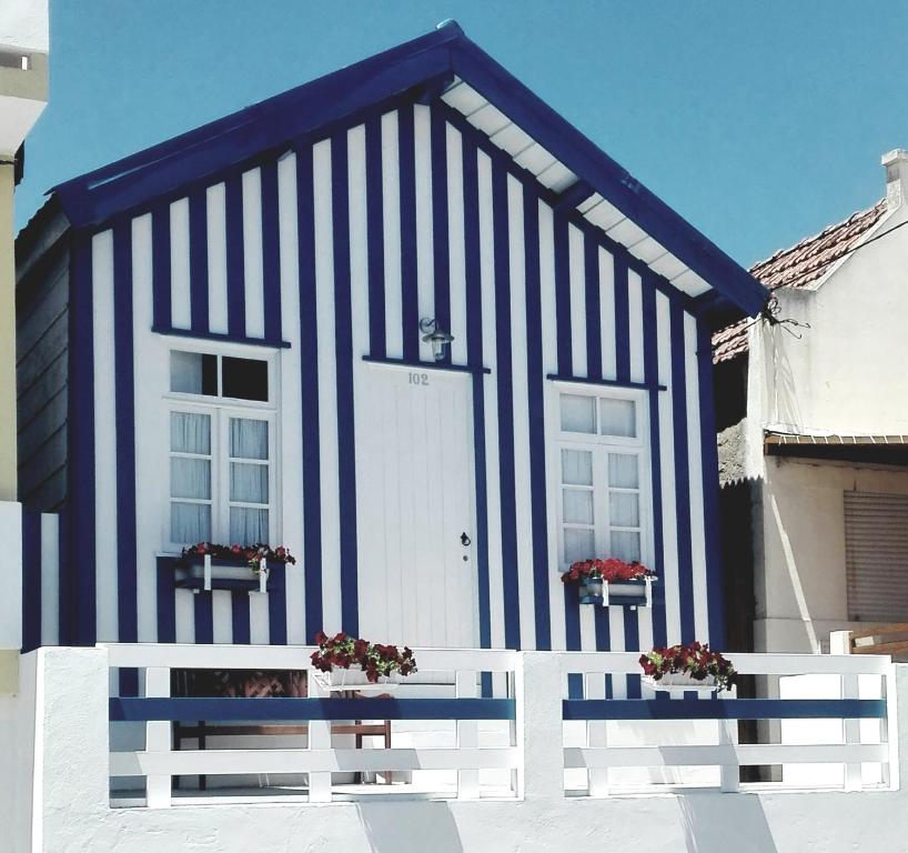 uma casa a preto e branco com uma cerca branca em Palheiro Costa Nova em Costa Nova