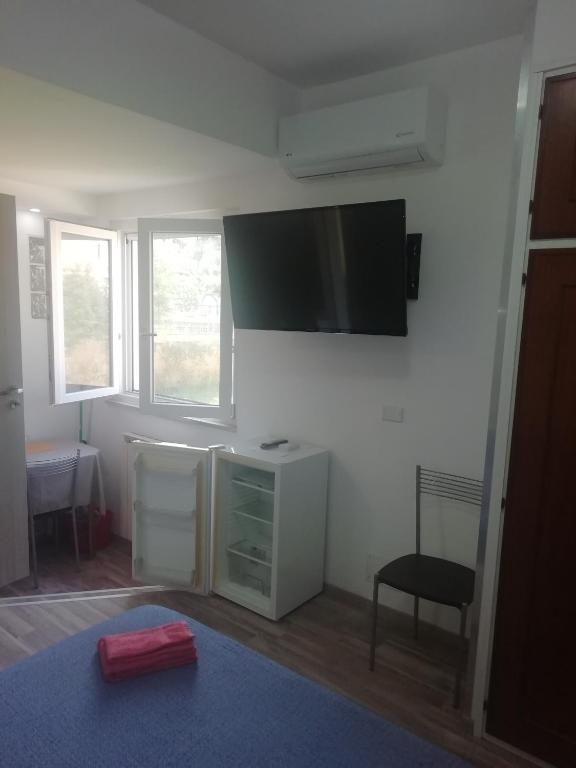 A television and/or entertainment centre at VILLA GIULIANA stanze con bagno interno in Villa a 350 mt spiaggia libera Lido delle Sirene