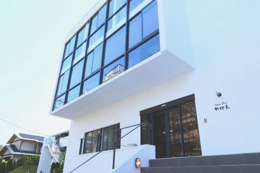 Casa blanca con puerta y ventanas negras en OceanFront YAHAN en Shimoda
