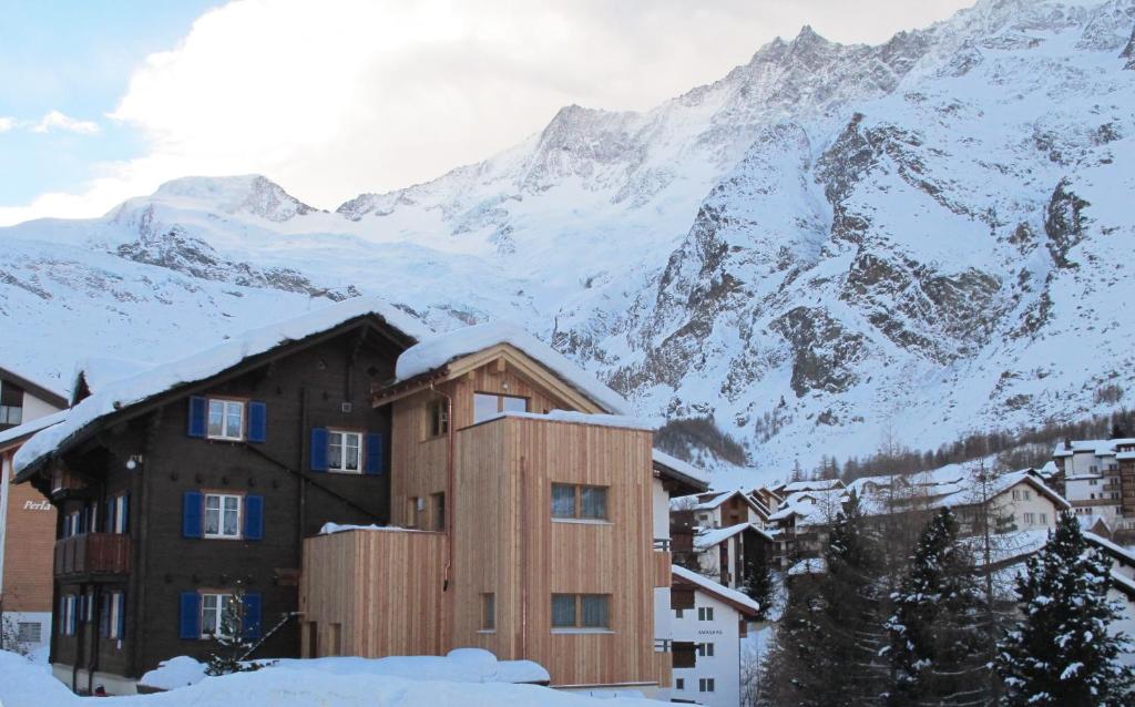 a building in front of a snow covered mountain at Apartment Dorfblick in Saas-Fee