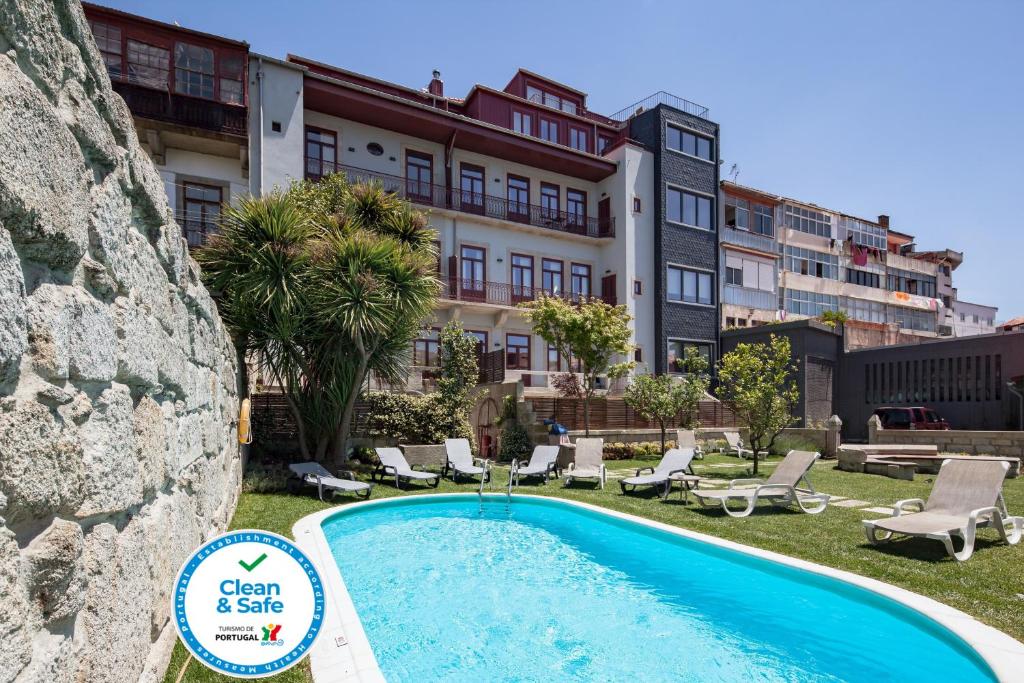 a large swimming pool in front of a large building at Aparthotel Oporto Alves da Veiga in Porto