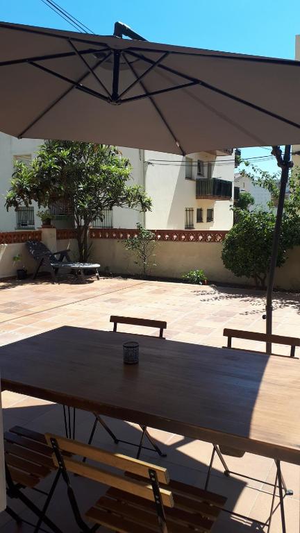 een tafel met twee stoelen en een parasol bij Apartament amb dues grans terrasses de 50 m2 i 16 m2 a 300 m de la platja in Sant Antoni de Calonge