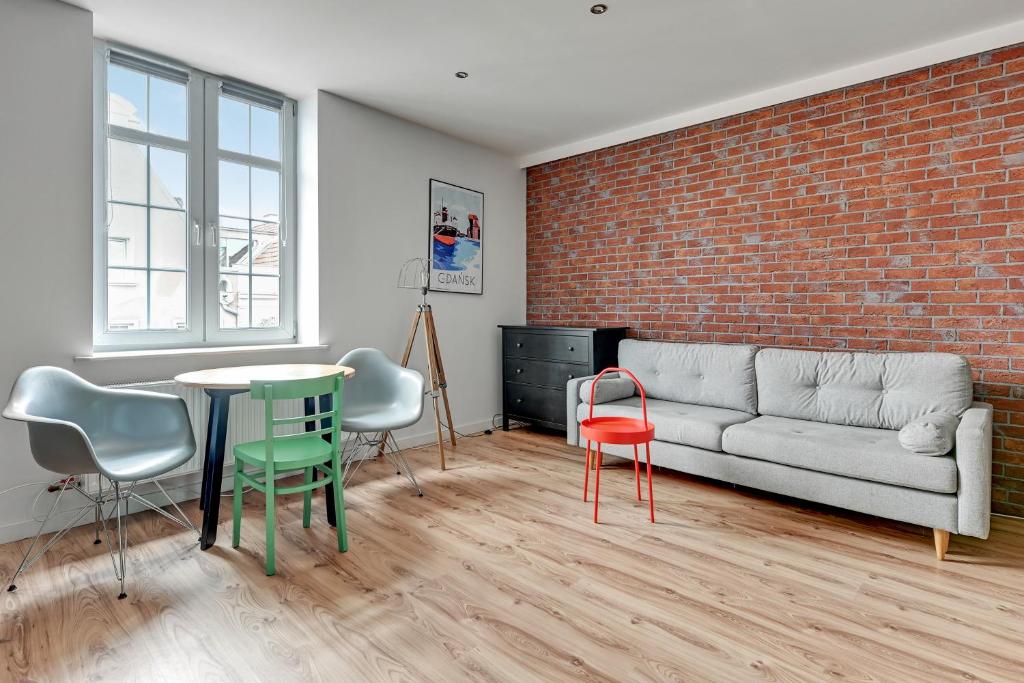 a living room with a couch and a table and chairs at Old Town Apartments Apartinfo in Gdańsk