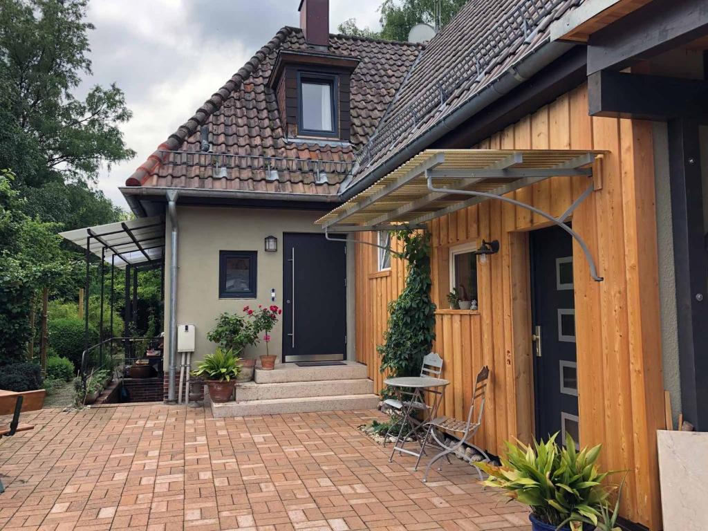 a house with a brick patio and a black door at Ferienwohnung Bartel in Coburg