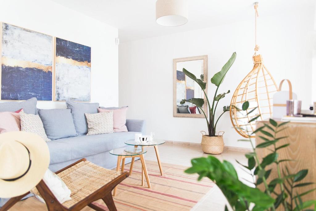 ein Wohnzimmer mit einem blauen Sofa und einem Tisch in der Unterkunft Lovely&Sunny Apartament Near Poris Beach in Santa Cruz de Tenerife