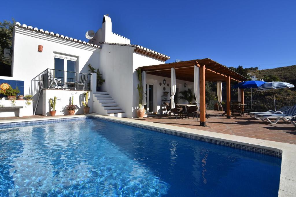 une villa avec une piscine en face d'une maison dans l'établissement Casa Nick, à Frigiliana