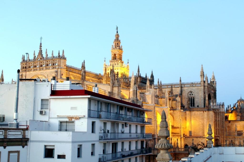 a large building with a cathedral in the background at HomeySeville-Amazing Views Cathedral Tomas de Ibarra - 8 pax, Parking Optional in Seville