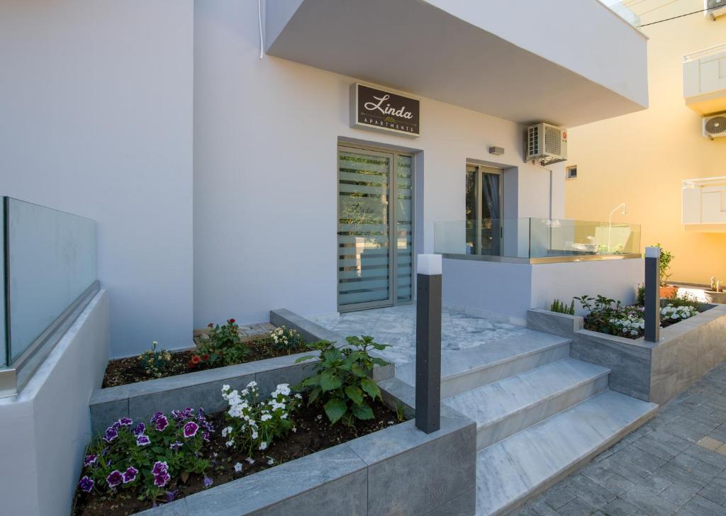 - un bâtiment avec des escaliers et des fleurs devant dans l'établissement Linda Apartments Platanias, à Platanias