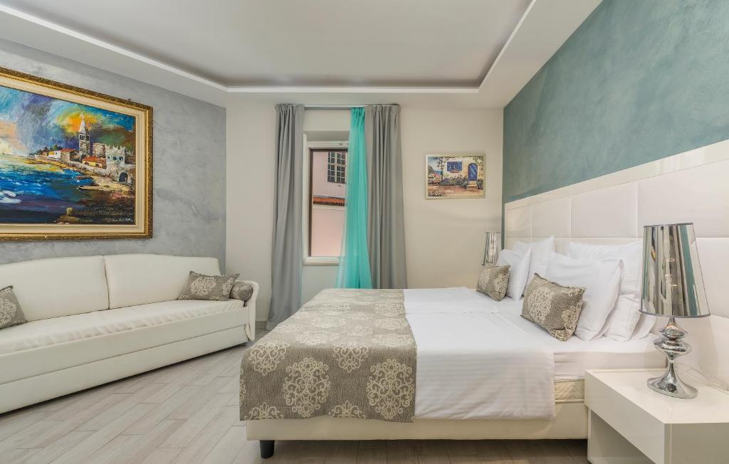 a bedroom with a white bed and a couch at Boutique Hotel Melissa in Poreč