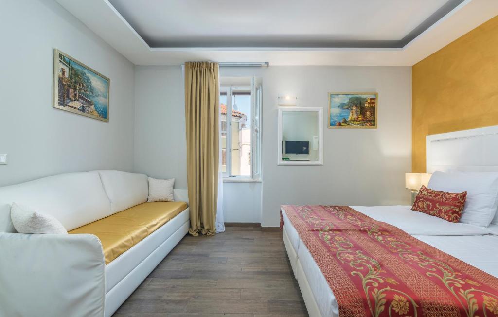 a hotel room with two beds and a couch at Boutique Hotel Melissa in Poreč