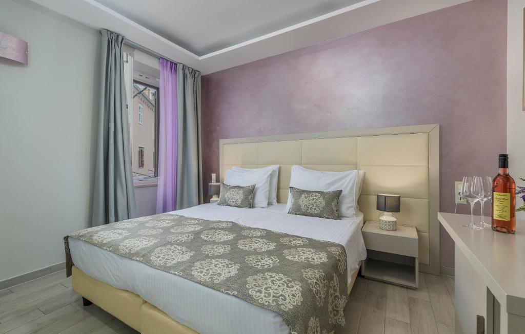 a bedroom with a large bed with purple walls at Boutique Hotel Melissa in Poreč