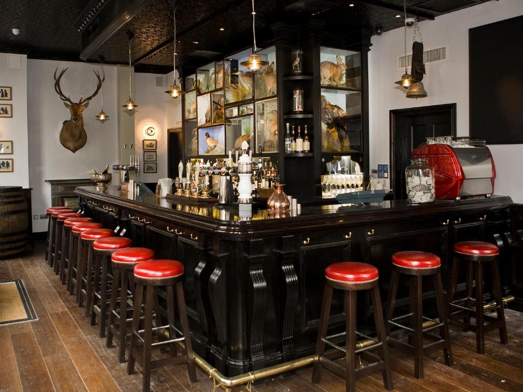 a bar with red stools in a room at Montcalm Brewery, London City in London