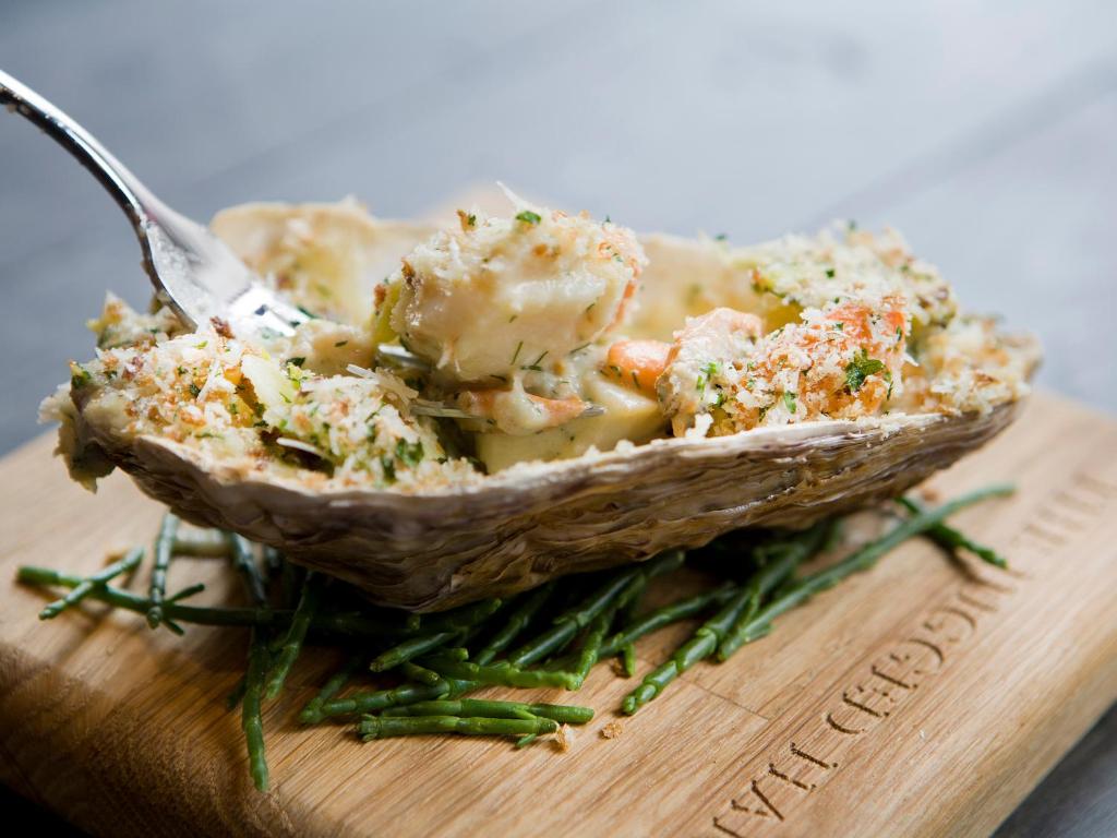 a bowl of food with a fork on a cutting board at Montcalm Brewery, London City in London