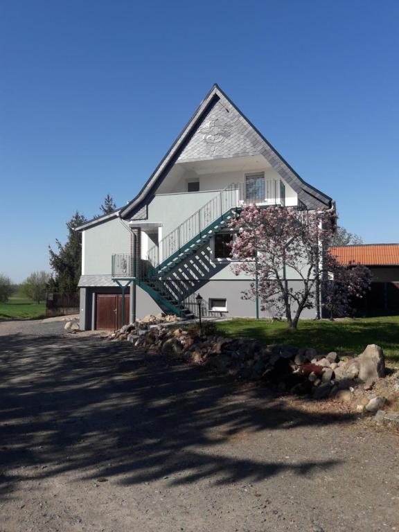 a white house with a staircase on the side of it at Ferienwohnung Junghanns in Kitzscher