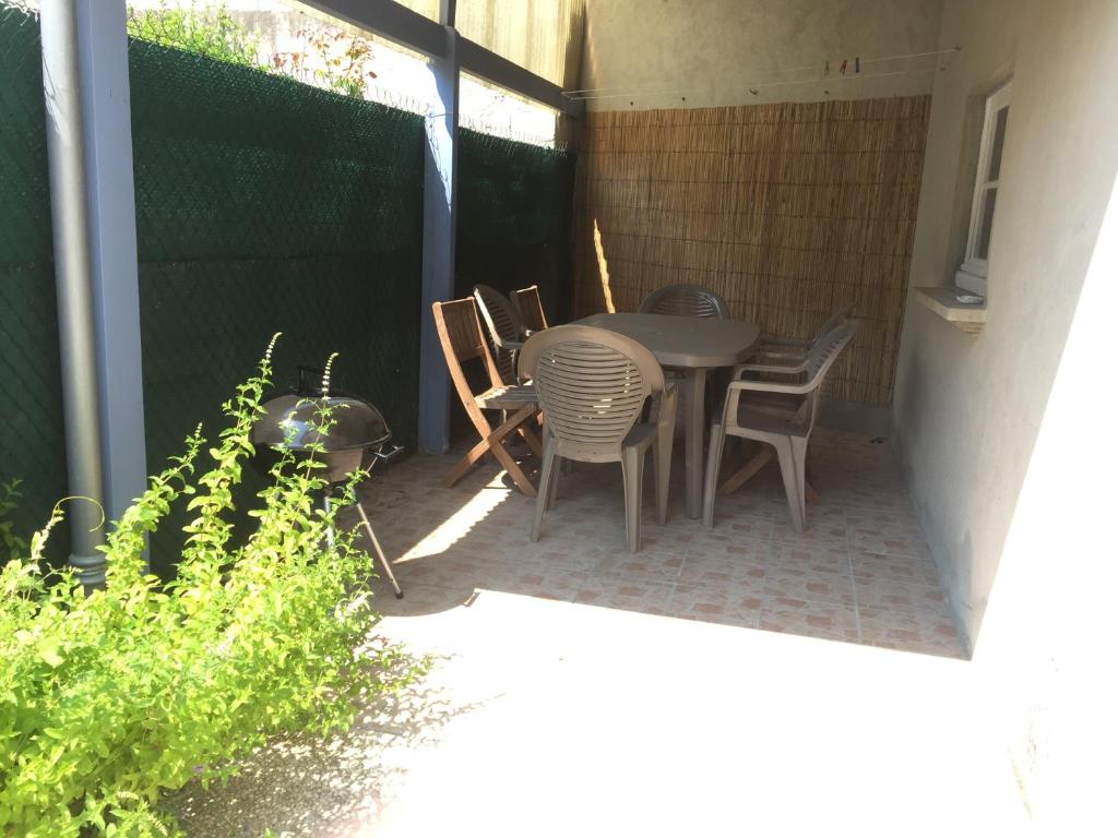 um pátio com uma mesa, cadeiras e uma cerca em CENTRE CHATELAILLON GRAND T3** AVEC COUR 100m PLAGE em Châtelaillon-Plage