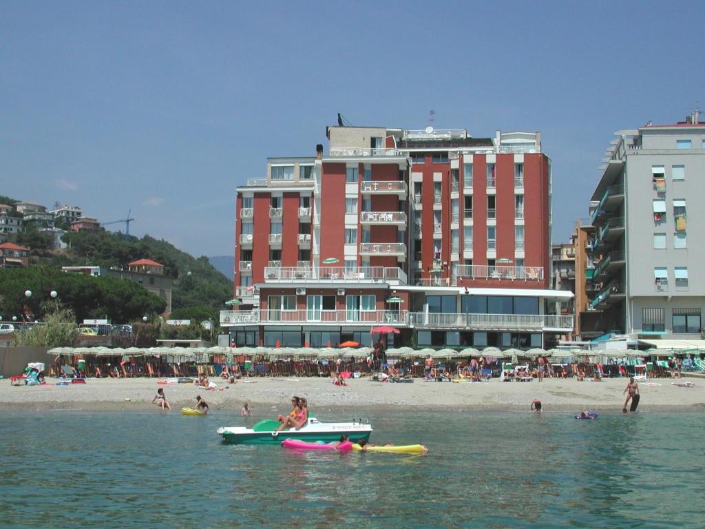 a group of people in the water at a beach at Residence Stella Maris in Pietra Ligure