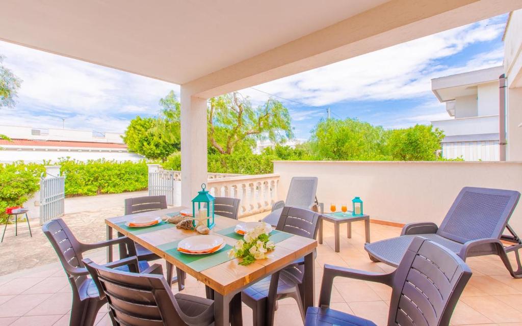 a patio with a table and chairs on a deck at Villa la Mezza Luna in Torre Santa Sabina