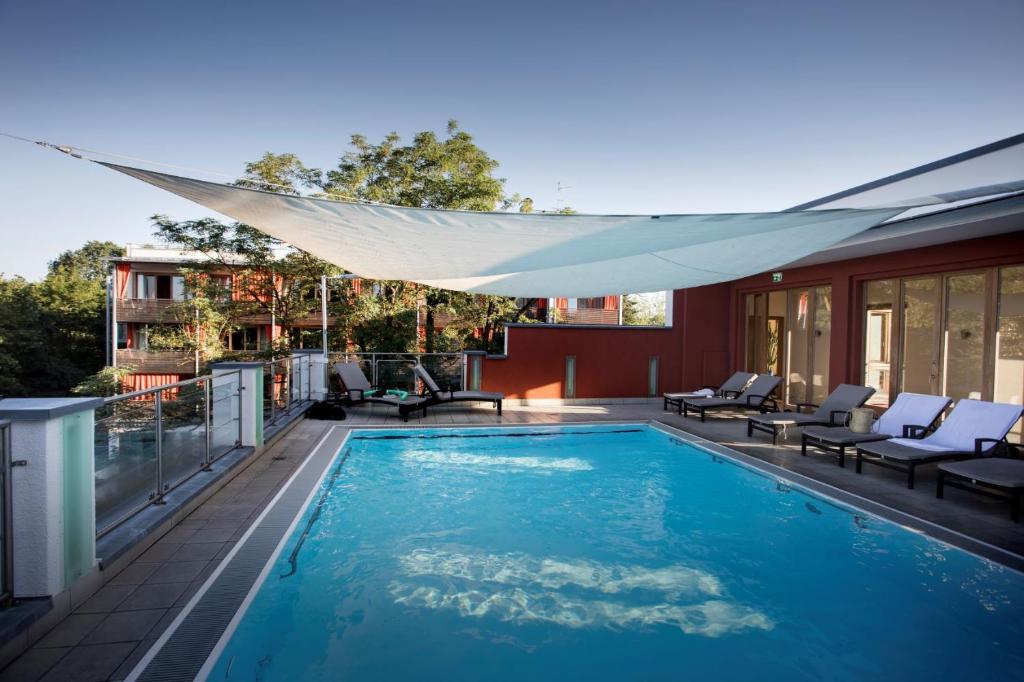 a swimming pool with a canopy on a house at Bio Thermalhotel Falkenhof in Bad Füssing