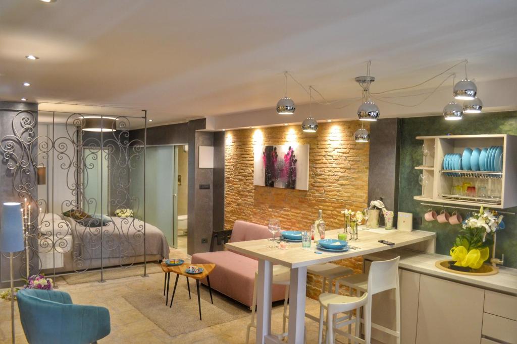 a kitchen and living room with a table and chairs at STUDIO APARTMAN ELEVEN in Rovinj