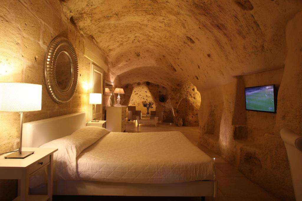 a bedroom with a bed in a stone room at Caveoso Hotel in Matera