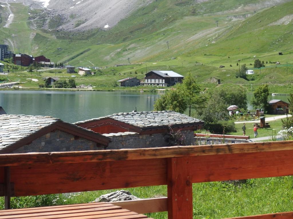 Elle offre une vue sur un lac avec des maisons et une montagne. dans l'établissement L'Embrune, à Tignes