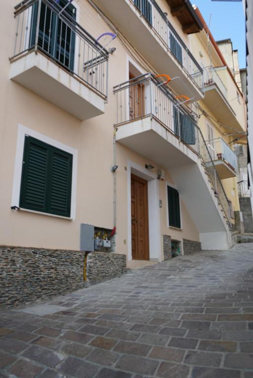 a building with two balconies and a cobblestone street at CASA con 2 camere da letto LOMBARDA BASSA in Falerna