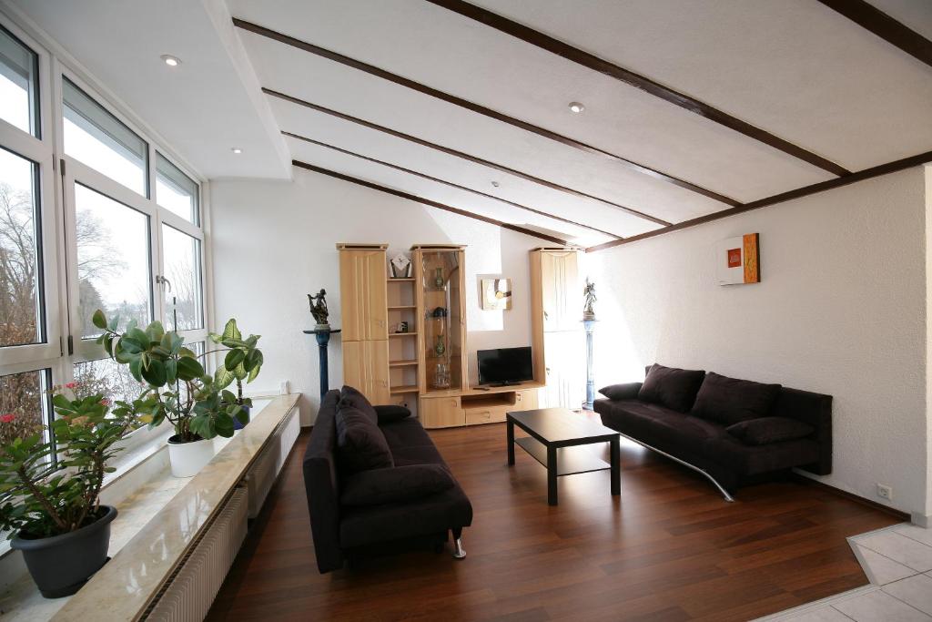 a living room with two couches and a tv at Apartment Hohenstaufen in Göppingen