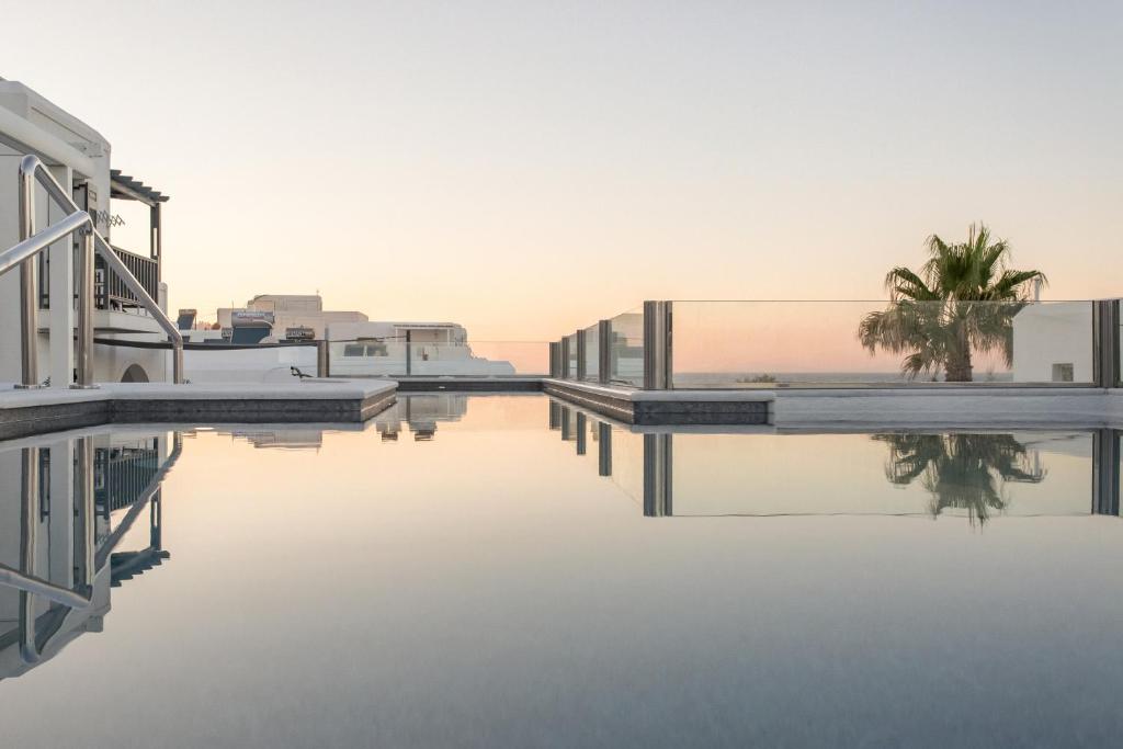 a view of a pool of water with houses and palm trees at Parian Boutique Hotel in Naousa