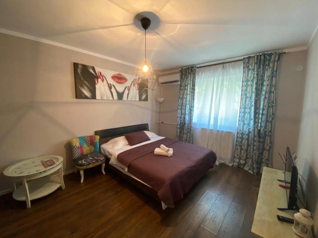 1 dormitorio con cama, mesa y ventana en 12 O'Clock Studio Bucharest, en Bucarest