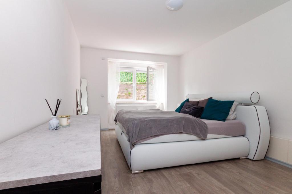 Habitación blanca con cama y ventana en Ferienwohnung Zschopau für Sie vollausgestattet mit Boxspringbett Netflix uvm, en Zschopau