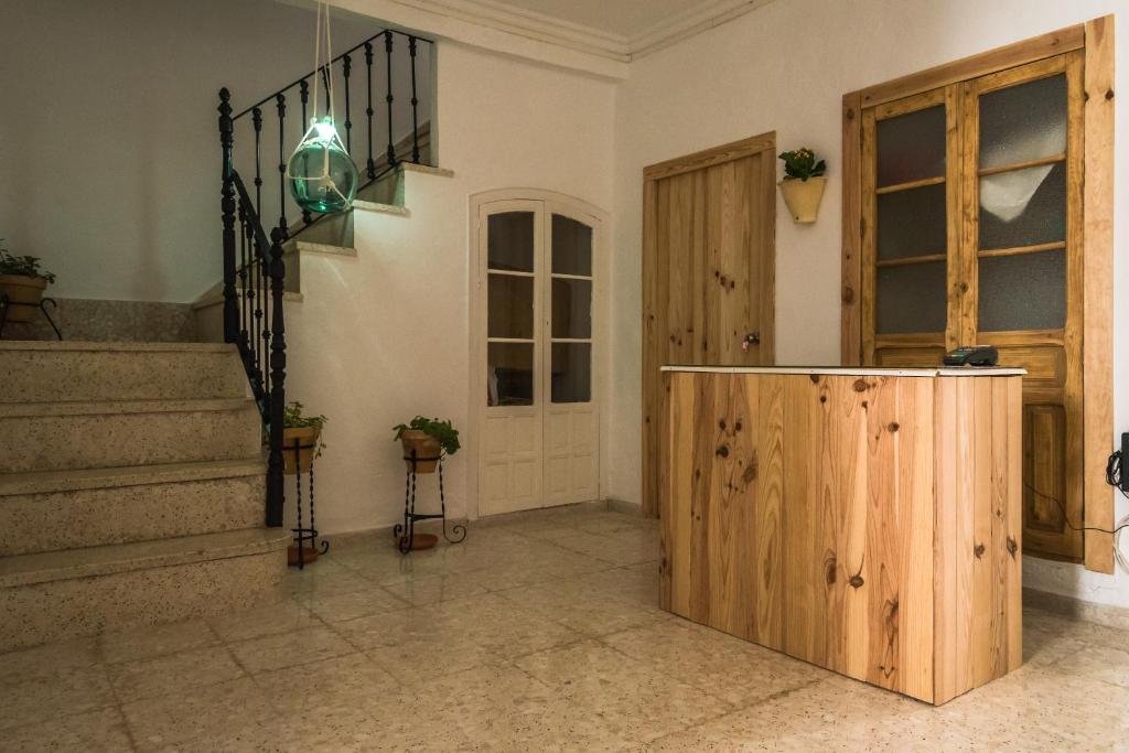 Habitación con escaleras, puerta de madera y escalera. en Olvera B&B Hostel en Olvera, en Olvera