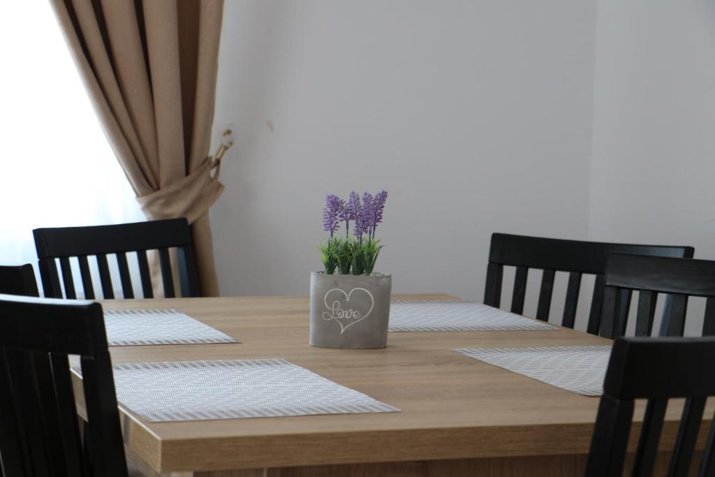 una mesa de madera con un jarrón de flores. en Casa Coman Moisei, en Moisei