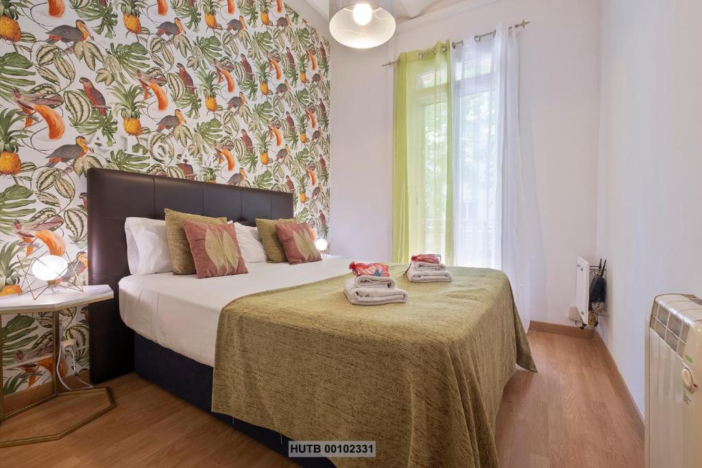 1 dormitorio con 1 cama con mesa y toallas en Alcam Montjuic, en Barcelona