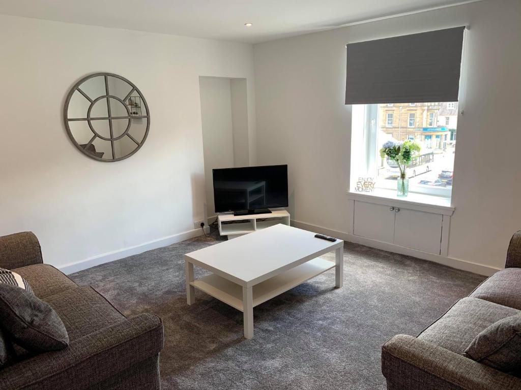 a living room with two couches and a coffee table at Town Centre Apartment in Hawick