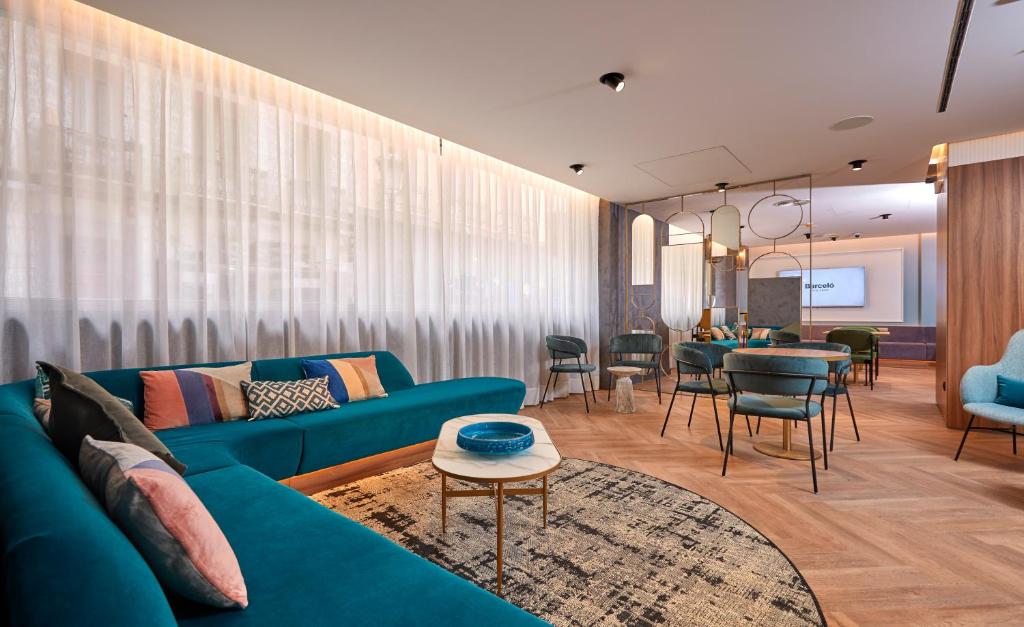 a living room with a blue couch and a table at Occidental Alicante in Alicante